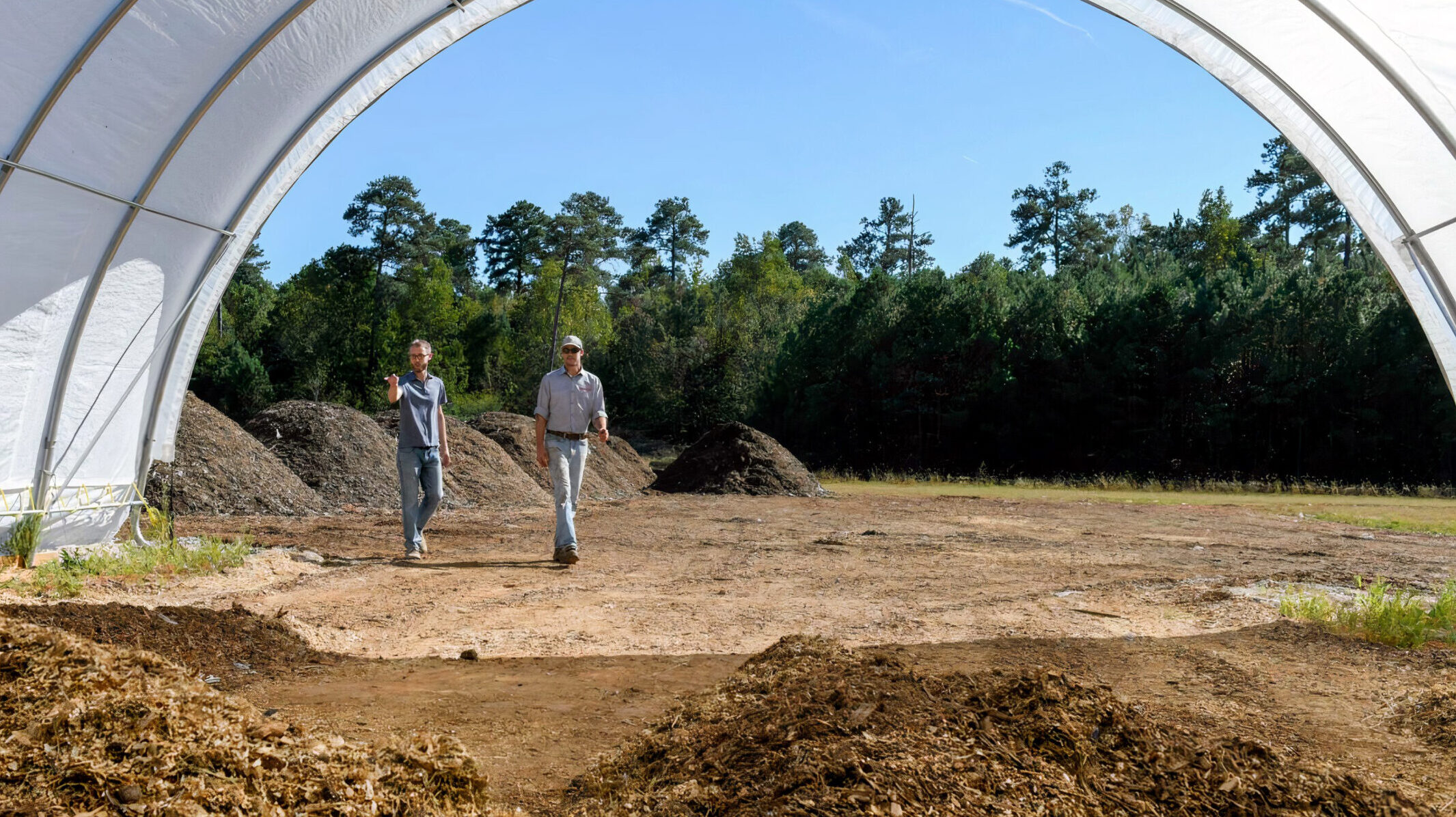 Two men look at compost at NC State