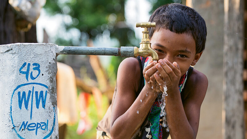 Boy drinks from water tap