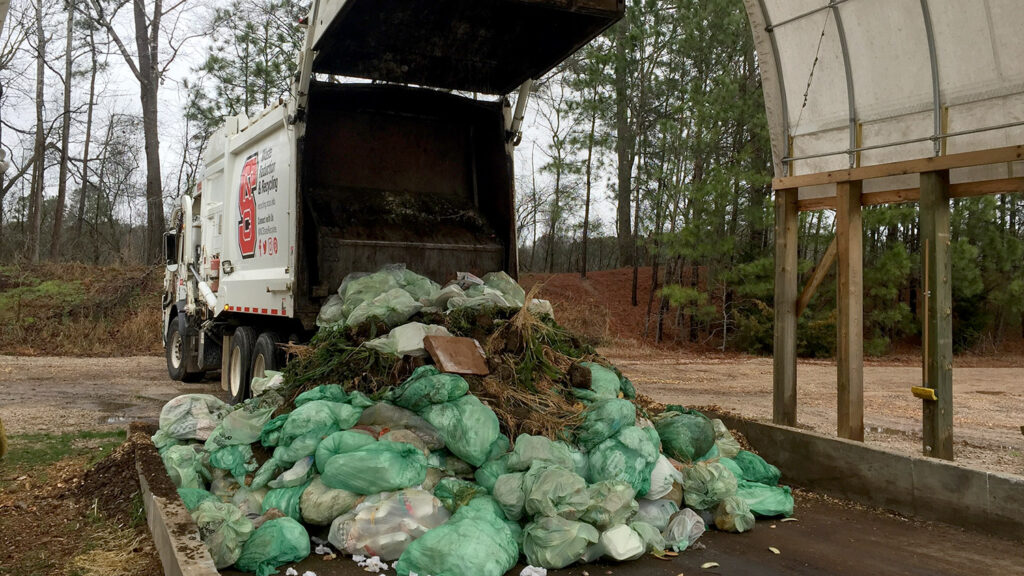 A recycling truck dumps bags on NC State's campus