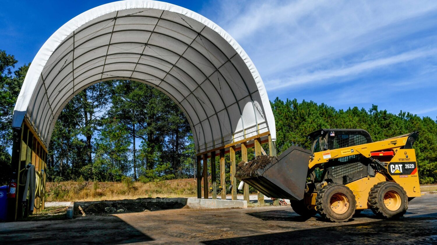 A loader carries materials on NC State's campus