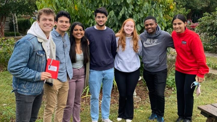 A group of seven young adults of different ethnicities and genders stand together smiling. Together they make up one team from the 2023-23 cohort of Fellows.