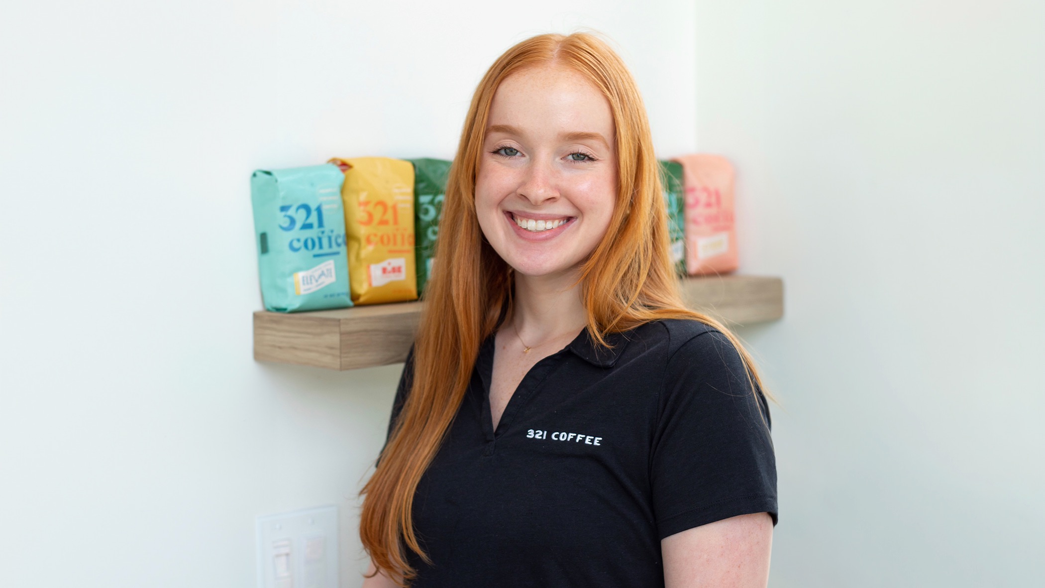 headshot of Audrey Westlund with bags of 321 coffee on a shelf nearby