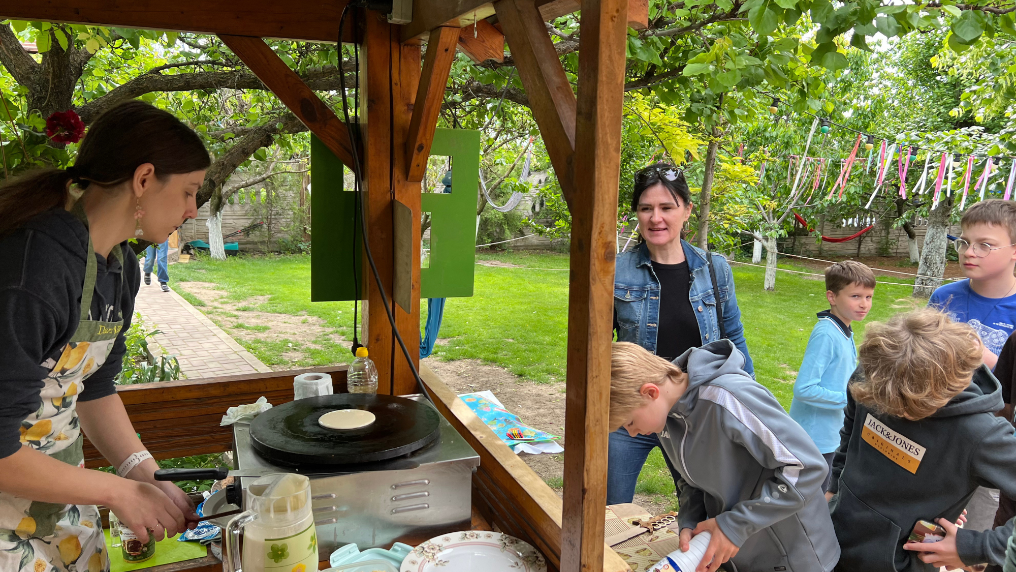A woman making traditional food for a group of children in Moldova.